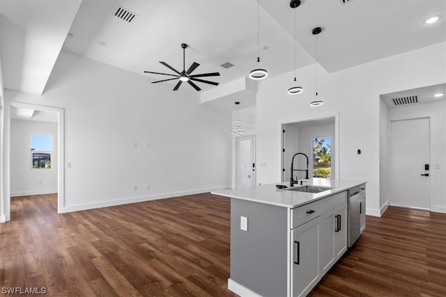 kitchen featuring sink, ceiling fan, dark hardwood / wood-style flooring, stainless steel dishwasher, and a center island with sink