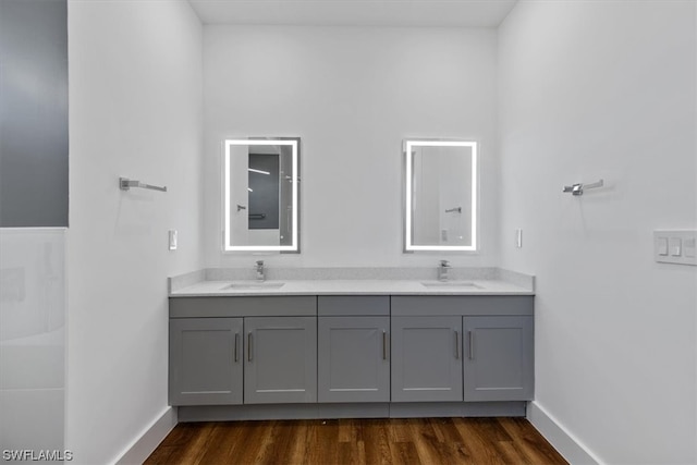 bathroom with dual vanity and wood-type flooring