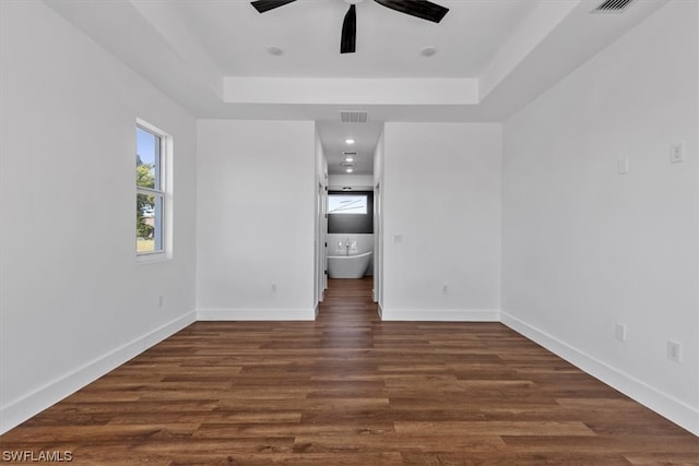 spare room with a raised ceiling, dark hardwood / wood-style floors, and ceiling fan