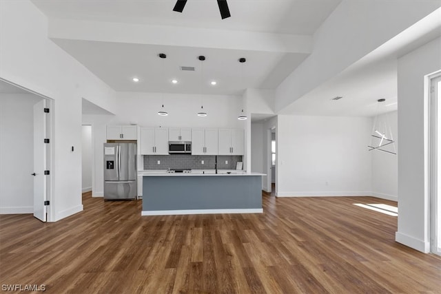 kitchen with white cabinetry, hanging light fixtures, appliances with stainless steel finishes, and dark hardwood / wood-style floors