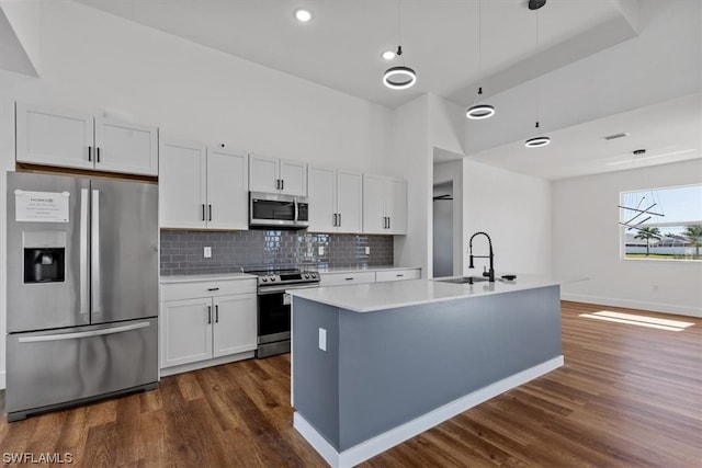 kitchen featuring dark hardwood / wood-style floors, stainless steel appliances, and white cabinets