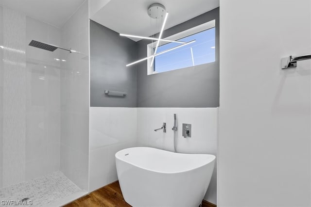 bathroom with hardwood / wood-style floors, tile walls, and tiled shower