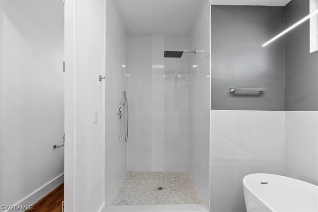 bathroom featuring a tile shower and tile walls