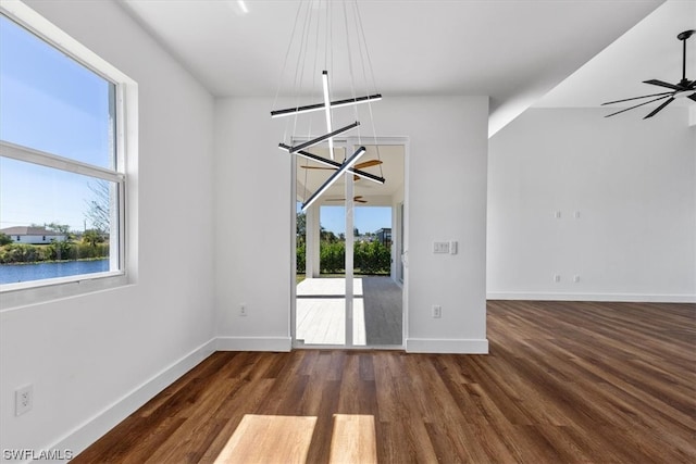 spare room featuring ceiling fan with notable chandelier and dark hardwood / wood-style flooring