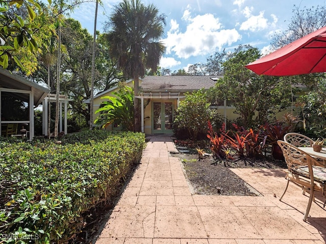 view of front facade featuring a shingled roof and a patio