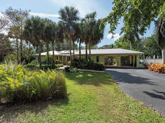 view of front of property featuring driveway, an attached carport, and a front yard