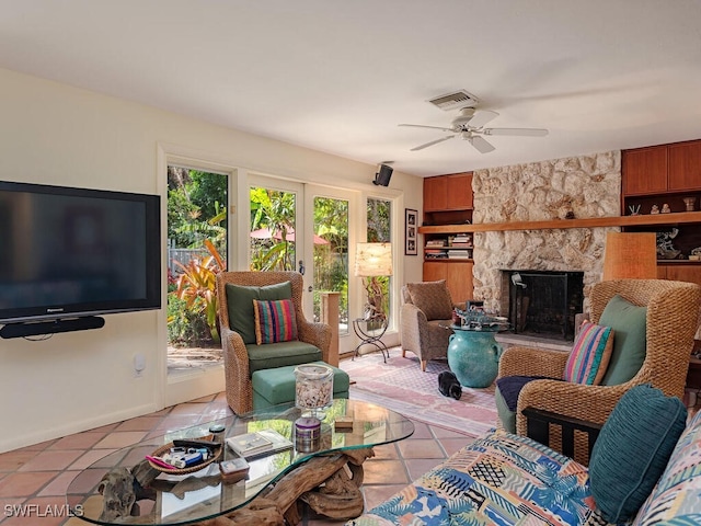 living room with french doors, a fireplace, light tile patterned floors, visible vents, and ceiling fan