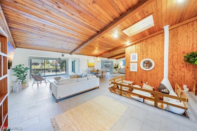 living room with a skylight, tile flooring, beam ceiling, wood ceiling, and wooden walls