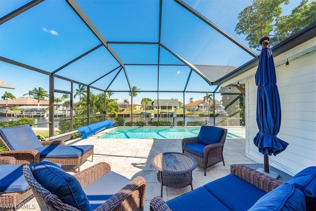 view of pool featuring a patio, an outdoor hangout area, and glass enclosure