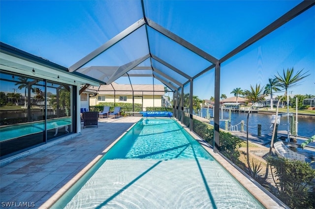 view of pool featuring glass enclosure, a water view, and a patio area