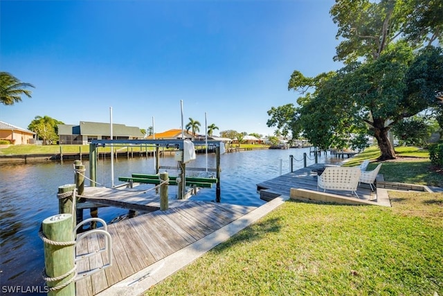 view of dock with a water view and a lawn