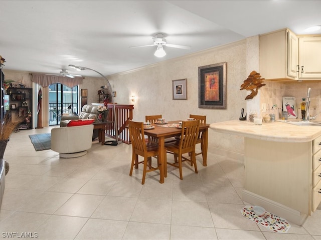 tiled dining room featuring ornamental molding and ceiling fan