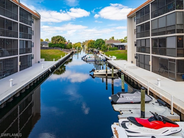 view of pool featuring a boat dock, a water view, and a lawn