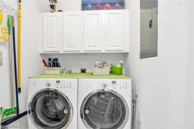 clothes washing area with cabinets, washer and dryer, and electric panel