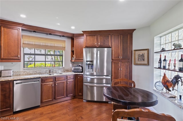 kitchen with light stone countertops, stainless steel appliances, dark hardwood / wood-style floors, and sink