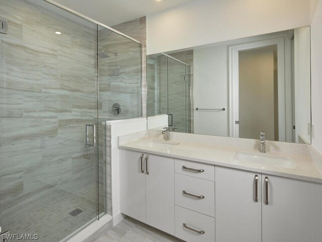 bathroom featuring vanity and a shower with door