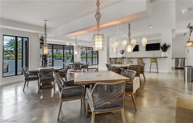 dining room with an inviting chandelier and concrete floors