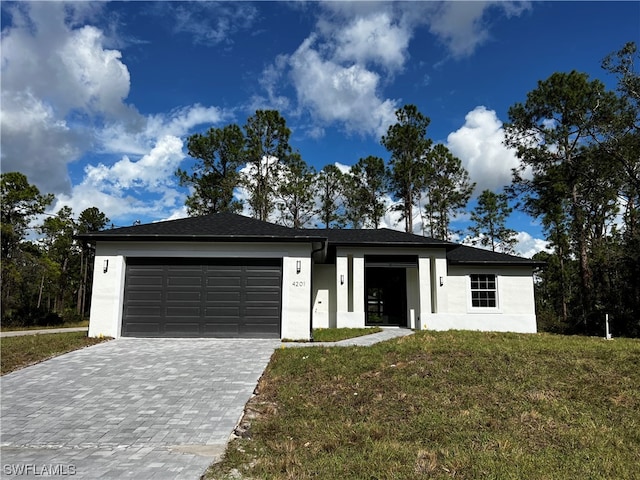 view of front of home featuring a front yard and a garage