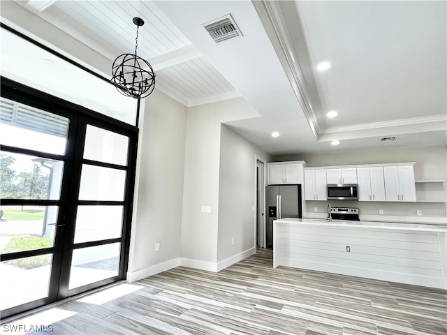 kitchen featuring french doors, hanging light fixtures, white cabinets, a chandelier, and stainless steel appliances