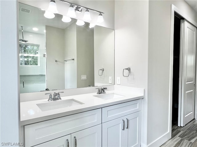 bathroom with tile flooring, vanity with extensive cabinet space, and dual sinks