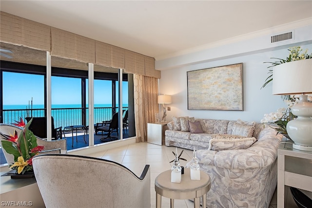 living room with crown molding, a water view, and light tile flooring