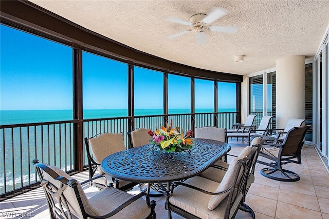 sunroom / solarium with a water view and ceiling fan