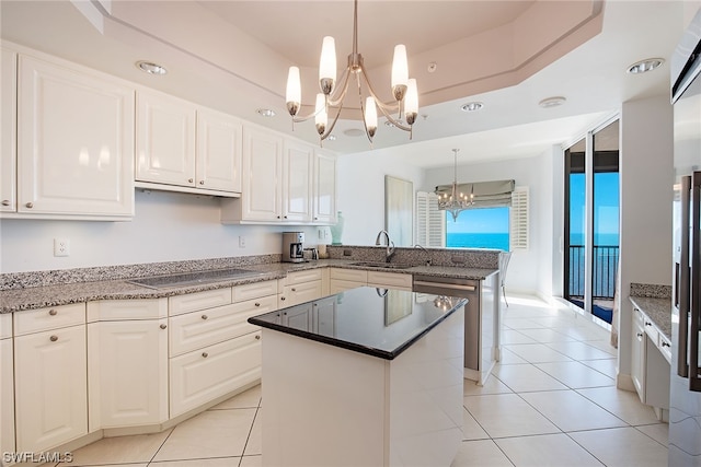 kitchen with a wealth of natural light, pendant lighting, a chandelier, and a center island