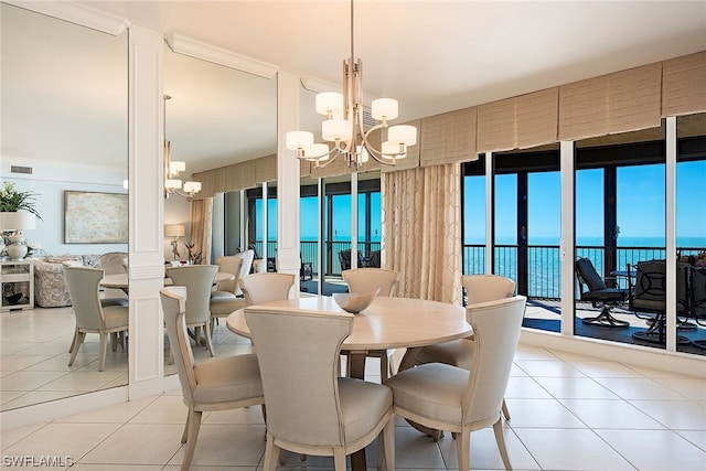 tiled dining space featuring a chandelier and a water view