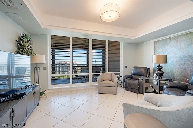 living room with light tile floors and a tray ceiling