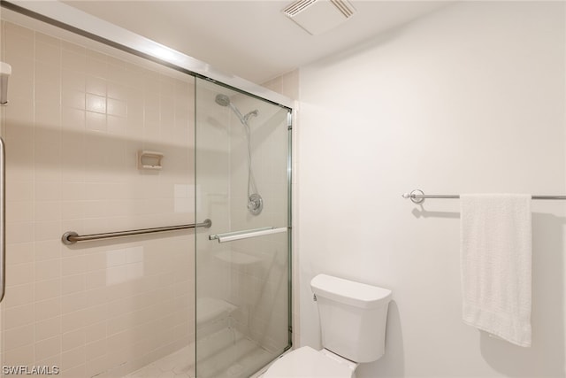 bathroom with toilet and a shower with shower door