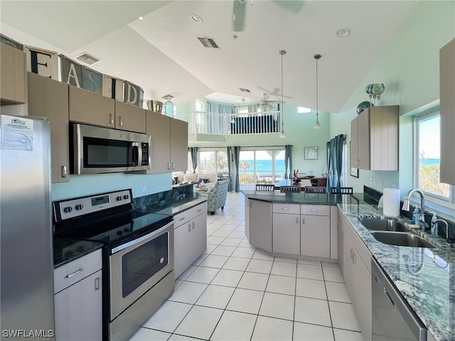 kitchen featuring high vaulted ceiling, light tile flooring, ceiling fan, appliances with stainless steel finishes, and sink