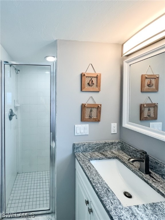 bathroom with a shower with shower door and large vanity