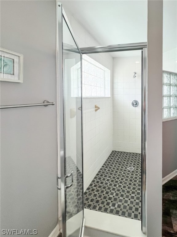 bathroom with an enclosed shower and wood-type flooring