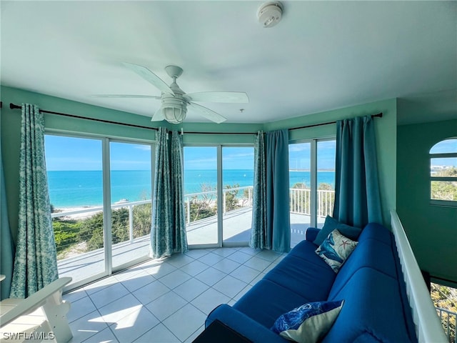 living room with a water view, light tile floors, and ceiling fan