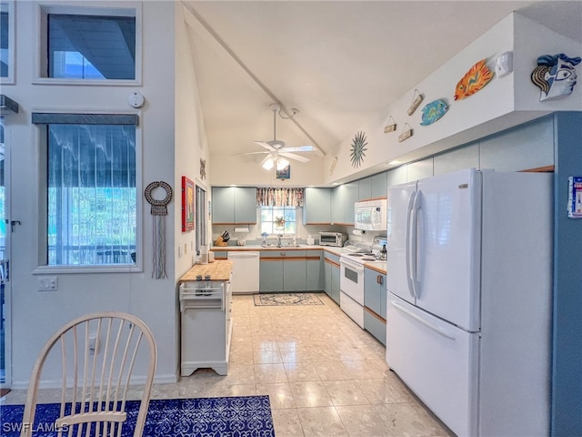 kitchen with white appliances, sink, lofted ceiling, light tile patterned flooring, and ceiling fan