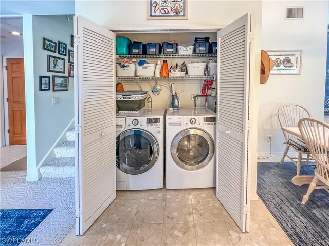 laundry area featuring separate washer and dryer and light tile patterned floors