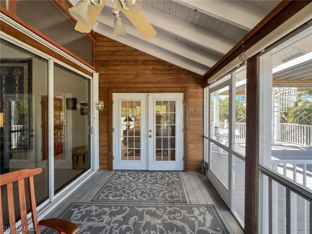 unfurnished sunroom featuring lofted ceiling with beams, french doors, and ceiling fan