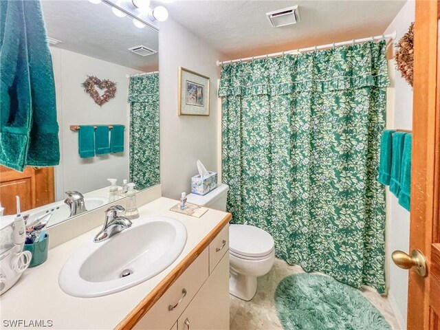 bathroom with vanity, tile patterned floors, a textured ceiling, and toilet