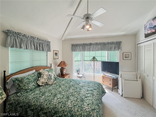 carpeted bedroom with a closet, lofted ceiling, and ceiling fan