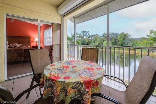 sunroom / solarium featuring a wall mounted air conditioner, a water view, and a healthy amount of sunlight