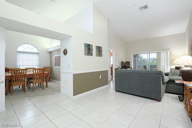 living room featuring light tile floors and high vaulted ceiling