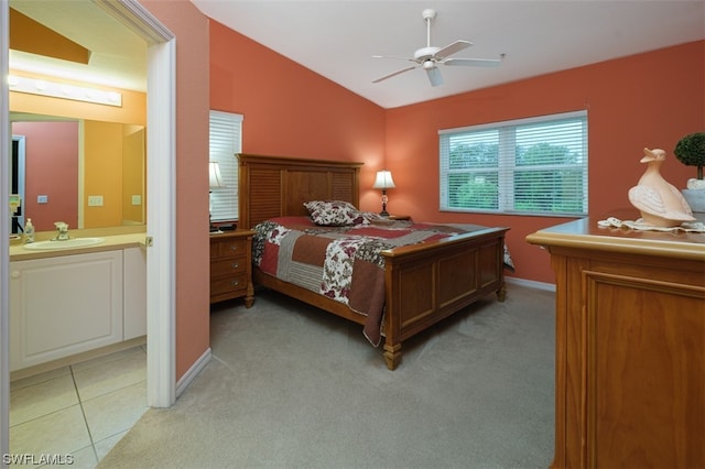 carpeted bedroom with ensuite bathroom, ceiling fan, vaulted ceiling, and sink