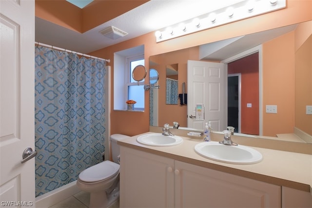 bathroom featuring toilet, double vanity, and tile flooring