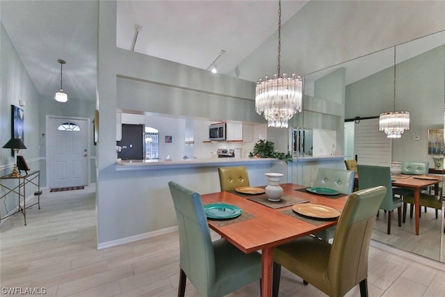 dining area featuring light hardwood / wood-style floors, high vaulted ceiling, and a chandelier