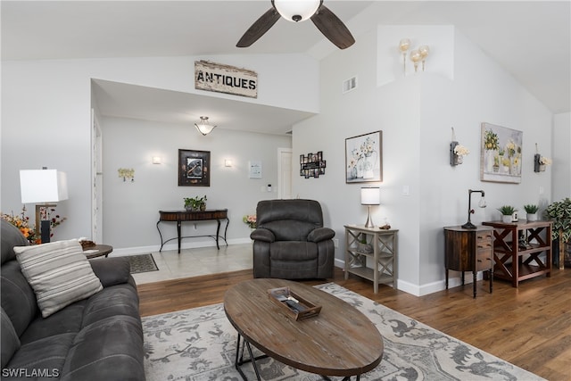 living room with tile flooring, ceiling fan, and vaulted ceiling