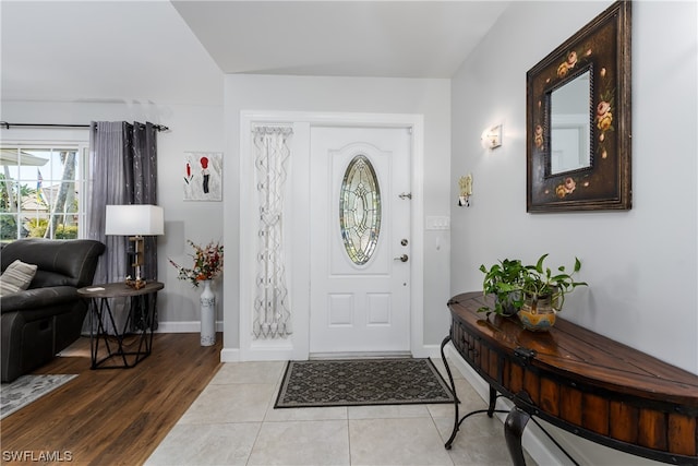 foyer with light wood-type flooring and lofted ceiling