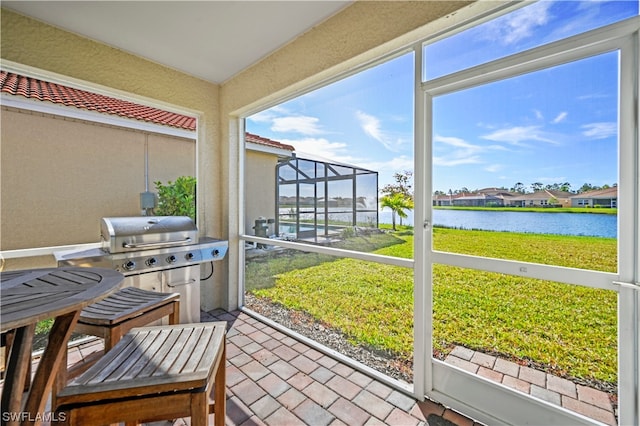 sunroom featuring a water view