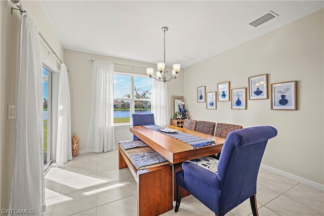 dining space featuring light tile flooring and an inviting chandelier