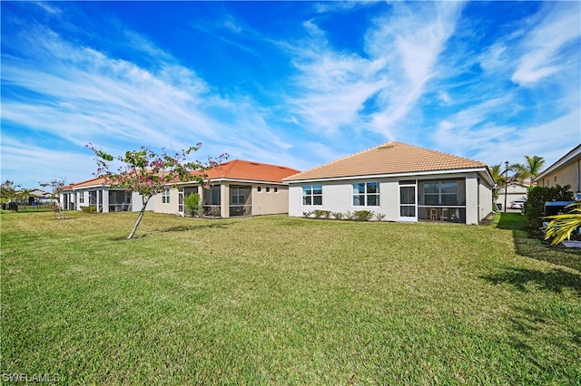 rear view of house featuring a lawn