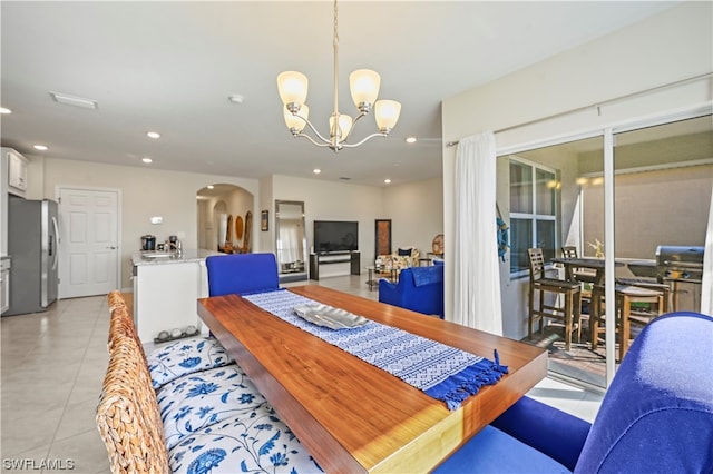 dining area featuring a chandelier and light tile floors